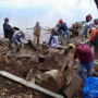 Volunteers pulling up trash at a dump site.